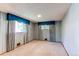 Spacious bedroom with blue striped wallpaper, two windows, and carpeted floors at 2081 W Ridge Rd, Littleton, CO 80120