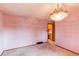 A bright dining room with pink walls, carpet and a decorative chandelier near a doorway to another room at 2081 W Ridge Rd, Littleton, CO 80120