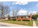 A view of the home's red brick facade, complemented by a well-maintained lawn and a partially fenced yard at 2081 W Ridge Rd, Littleton, CO 80120