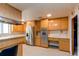Open concept kitchen features wood cabinets, stainless refrigerator, and breakfast bar at 2081 W Ridge Rd, Littleton, CO 80120