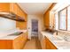 Well-lit kitchen features wood cabinets, electric stovetop, and built-in dishwasher at 2081 W Ridge Rd, Littleton, CO 80120