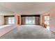 Spacious living room featuring pink walls, carpet, a fireplace, large windows and a partial mirror wall at 2081 W Ridge Rd, Littleton, CO 80120