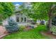 Landscaped front yard with mature trees, flowering shrubs, and manicured lawn at 1080 Tantra Park Cir, Boulder, CO 80305