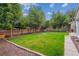 Spacious backyard featuring a lush lawn, mature trees, and a wooden fence at 962 Uvalda St, Aurora, CO 80011