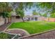 Expansive backyard with lush lawn, mature trees, and inviting patio area at 962 Uvalda St, Aurora, CO 80011