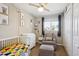 Cozy bedroom with a neutral color palette and a crib with a colorful quilt at 962 Uvalda St, Aurora, CO 80011