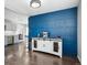 Dining area with wainscoting accent wall, wood floors, and updated kitchen view at 962 Uvalda St, Aurora, CO 80011