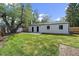 This backyard features a well-manicured lawn, a small patio, and mature trees at 1360 S Forest Way, Denver, CO 80222
