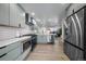 Contemporary kitchen featuring stainless steel appliances, light gray cabinetry, and open access to the living area at 1360 S Forest Way, Denver, CO 80222
