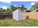 A white storage shed sits in the corner of the backyard behind a wood fence at 1360 S Forest Way, Denver, CO 80222