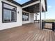 This back porch includes dark wood flooring, modern white pillars, and beautiful views at 62101 E 32Nd Ct, Strasburg, CO 80136