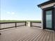 Relax on the dark wooden porch and enjoy views of the adjacent green space and blue sky at 62101 E 32Nd Ct, Strasburg, CO 80136