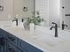 Bathroom vanity features dual sinks, quartz countertop, dark navy cabinets, and sleek black fixtures at 62101 E 32Nd Ct, Strasburg, CO 80136