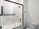 Modern bathroom with sleek glass shower doors and white marble-style tiling at 62101 E 32Nd Ct, Strasburg, CO 80136