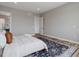 Neutral bedroom design with light walls, wood floors, decorative area rug, and doorway to the bathroom at 62101 E 32Nd Ct, Strasburg, CO 80136