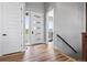 Inviting entryway with wood floors, modern white door, and abundant natural light at 62101 E 32Nd Ct, Strasburg, CO 80136
