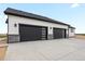 Modern home featuring a three-car garage with dark doors and contemporary design at 62101 E 32Nd Ct, Strasburg, CO 80136