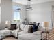 Bright living area featuring a plush sofa, modern lighting, and open dining space at 62101 E 32Nd Ct, Strasburg, CO 80136