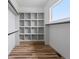 Walk-in closet features custom shelving, wood flooring, and ample storage space for organizing clothes at 62101 E 32Nd Ct, Strasburg, CO 80136