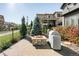 Backyard view with stone fire pit, lush landscaping, and patio with outdoor kitchen at 6938 E Lake Dr, Centennial, CO 80111