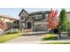 Handsome two-story home with stone details, manicured lawn, and paved driveway at 6938 E Lake Dr, Centennial, CO 80111