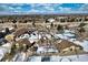 Aerial view of community with clubhouse, tennis courts, pool, and snow-covered landscape at 13739 E Marina Dr # B, Aurora, CO 80014