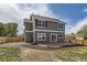 A backyard featuring a gray two-story house, a brick patio, and a wooden fence at 1488 N Stratton Ave, Castle Rock, CO 80104