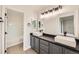 Elegant bathroom featuring dual vessel sinks, dark gray cabinets, tile flooring and a view of the tub/shower at 1488 N Stratton Ave, Castle Rock, CO 80104