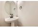 Stylish powder room featuring a pedestal sink with a modern faucet and an oval mirror at 1488 N Stratton Ave, Castle Rock, CO 80104