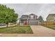 Inviting two-story home with gray siding, red door and shutters, a well-kept lawn, and an attached two-car garage at 1488 N Stratton Ave, Castle Rock, CO 80104