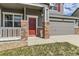 Inviting front entrance with a red door, brick accents, and a cozy porch, enhancing curb appeal and charm at 1488 N Stratton Ave, Castle Rock, CO 80104