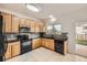 Bright kitchen featuring wood cabinetry, black appliances, granite countertops, and tile flooring for a functional space at 1488 N Stratton Ave, Castle Rock, CO 80104