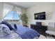Serene bedroom showcasing a comfortable bed, mounted TV and a window with natural light at 18027 Telford Ave, Parker, CO 80134