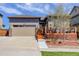 Charming home featuring a two-car garage, stone accents, and a cozy wooden deck with outdoor seating at 18027 Telford Ave, Parker, CO 80134