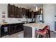 The gourmet kitchen features dark cabinets, granite counters, tile backsplash, and stainless steel appliances at 18027 Telford Ave, Parker, CO 80134