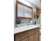 Bathroom featuring a wooden vanity, medicine cabinet, and a complementary wall shelf at 4580 W 109Th Ave, Westminster, CO 80031