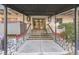 Apartment building entrance with red railings, stone landscaping, and glass doors at 1441 N Humboldt St # 504, Denver, CO 80218
