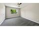 A bright bedroom featuring neutral walls, grey carpet, and a large window at 971 Ursula St, Aurora, CO 80011