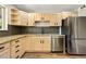 Charming kitchen features stainless steel appliances, granite countertops, and natural wood cabinetry at 971 Ursula St, Aurora, CO 80011