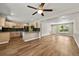 Open-concept living room featuring hardwood floors, recessed lighting and neutral paint flowing to kitchen at 971 Ursula St, Aurora, CO 80011