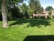 Large backyard with lush grass and mature trees at 5030 Aspen Dr, Littleton, CO 80123