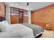 Bedroom with brick wall and wood dresser at 5030 Aspen Dr, Littleton, CO 80123