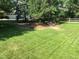 Neatly kept lawn with mature trees and a partial view of the home at 5030 Aspen Dr, Littleton, CO 80123