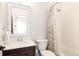 Traditional bathroom with a wood vanity, white sink, and shower with floral curtain at 10106 E 59Th Pl, Denver, CO 80238