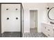 Modern bathroom with a glass-enclosed shower, black fixtures, and patterned tile flooring at 10106 E 59Th Pl, Denver, CO 80238