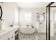 Bright bathroom featuring double vanity, freestanding tub, patterned tile, and glass shower at 10106 E 59Th Pl, Denver, CO 80238