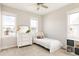Bright bedroom featuring a bed, dresser, carpet and ample natural light from three windows at 10106 E 59Th Pl, Denver, CO 80238