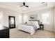 Bright bedroom featuring a tray ceiling, carpet, and a large window with plantation shutters at 10106 E 59Th Pl, Denver, CO 80238