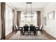 Elegant dining room featuring a large table, modern chandelier, and ample natural light at 10106 E 59Th Pl, Denver, CO 80238