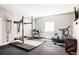 Home gym featuring a squat rack, weightlifting platform, and stationary bike for a complete workout space at 10106 E 59Th Pl, Denver, CO 80238